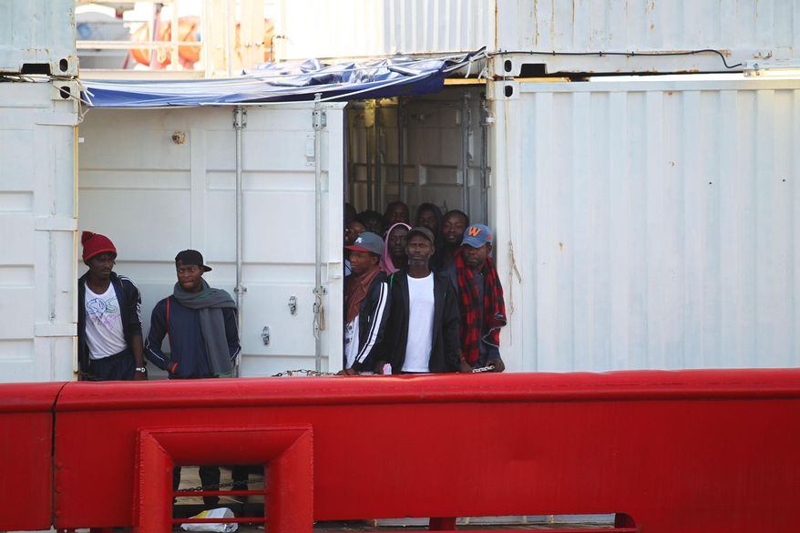 Migrants aboard the Ocean Viking rescue ship look around as they enter in the commercial port of Taranto, in Taranto, southern Italy, Wednesday, Oct. 16, 2019. The ship run by SOS Mediterranee rescued 176 migrants. (Ingenito/ANSA via AP)