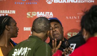 Boxer Ivana Habazin&#39;s trainer Bashir Ali, right, trash talks with members of Claressa Shields&#39; entourage during a weigh-in Friday, Oct. 4, 2019, in Flint, Mich. Ali was later punched by a man and fell to the ground bloodied. He was sent to McLaren Hospital in Flint to be treated. Habazin and Claressa Shields are scheduled to fight Saturday for the WBO and WBC super welterweight championships. (Jake May/The Flint Journal via AP)