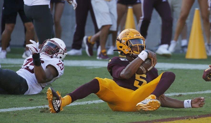 Arizona State quarterback Jayden Daniels (5) scores a touchdown as he eludes Washington State safety Skyler Thomas (25) during the second half of an NCAA college football game Saturday, Oct. 12, 2019, in Tempe, Ariz. (AP Photo/Ross D. Franklin)