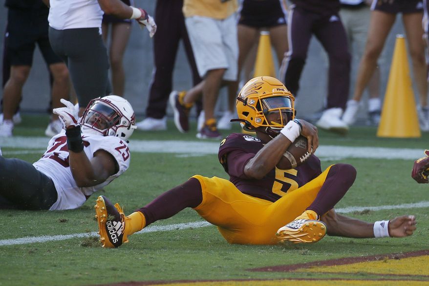 Arizona State quarterback Jayden Daniels (5) scores a touchdown as he eludes Washington State safety Skyler Thomas (25) during the second half of an NCAA college football game Saturday, Oct. 12, 2019, in Tempe, Ariz. (AP Photo/Ross D. Franklin)