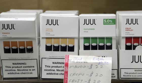  In this Thursday, Dec. 20, 2018 file photo, Juul products are displayed at a smoke shop in New York. On Thursday, Oct. 17, 2019, the company announced it will voluntarily stop selling its fruit and dessert-flavored vaping pods. (AP Photo/Seth Wenig) **FILE**