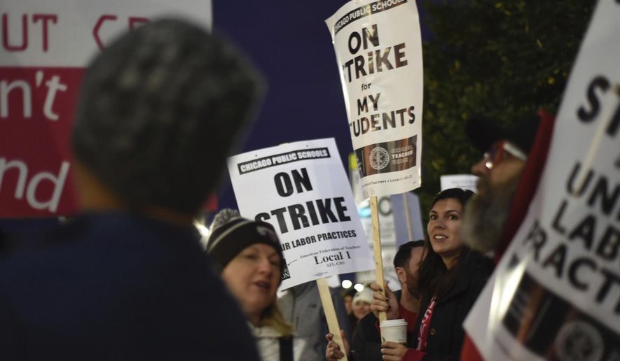Chicago Public Schools teachers picket early Thursday morning, Oct. 17, 2019, at Lane Tech High School on the first day of a teacher&#x27;s strike, in Chicago. (Colin Boyle/Chicago Sun-Times via AP)