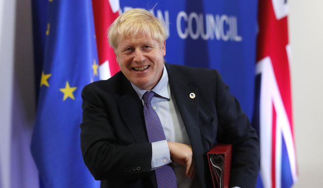 British Prime Minister Boris Johnson leaves the podium after addressing a media conference at an EU summit in Brussels, Thursday, Oct. 17, 2019. Britain and the European Union reached a new tentative Brexit deal on Thursday, hoping to finally escape the acrimony, divisions and frustration of their three-year divorce battle. (AP Photo/Frank Augstein)
