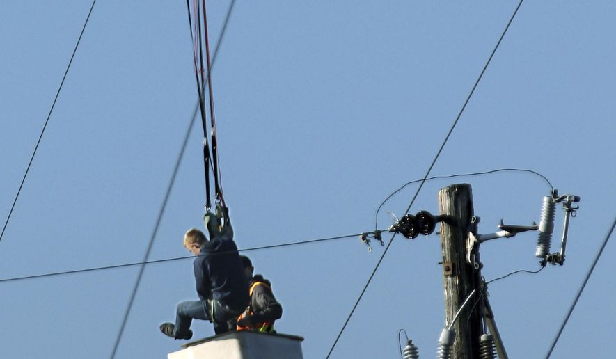 A BASE jumper was rescued from a city of Menomonie bucket truck after he became tangled in guy wires of a 300 ft. tower he jumped from in Menomonie, Wis., on Oct. 17, 2019. He was arrested for criminal trespass after his parachute got tangled in the guy wires of a cell phone tower in northwestern Wisconsin. Police say the 20-year-old man was illegally jumping from a 300-foot Charter Communications tower in Menomonie Thursday when his chute got tangled in the wires leaving him dangling 50 feet above ground. He called police for help.(Dan Reiland/The Eau Claire Leader-Telegram via AP)