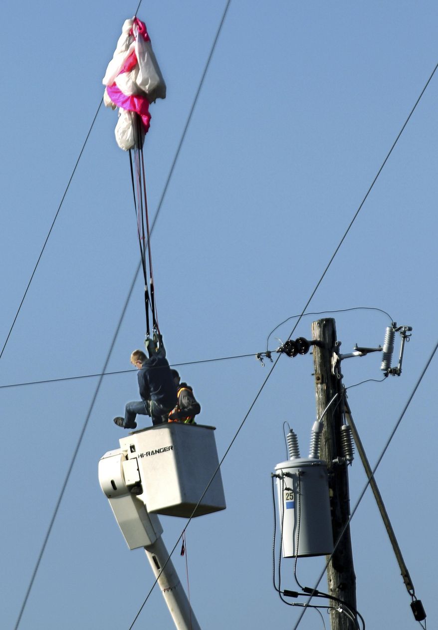 A BASE jumper was rescued from a city of Menomonie bucket truck after he became tangled in guy wires of a 300 ft. tower he jumped from in Menomonie, Wis., on Oct. 17, 2019. He was arrested for criminal trespass after his parachute got tangled in the guy wires of a cell phone tower in northwestern Wisconsin. Police say the 20-year-old man was illegally jumping from a 300-foot Charter Communications tower in Menomonie Thursday when his chute got tangled in the wires leaving him dangling 50 feet above ground. He called police for help.(Dan Reiland/The Eau Claire Leader-Telegram via AP)