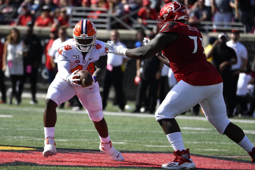 Clemson defensive tackle Nyles Pinckney (44) makes an interception away from the defense of Louisville offensive lineman Mekhi Becton (73) during the first half of an NCAA college football game in Louisville, Ky., Saturday, Oct. 19, 2019. (AP Photo/Timothy D. Easley)