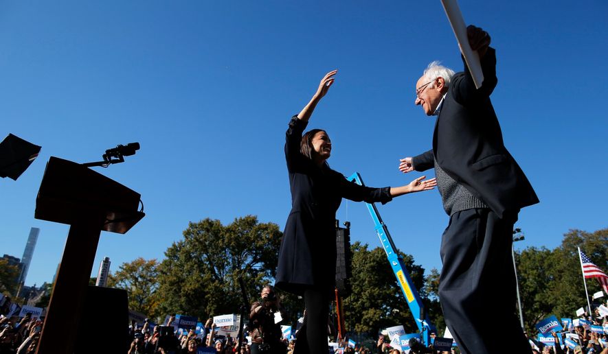 Democratic presidential candidate Sen. Bernie Sanders, I-Vt., hugs Rep. Alexandria Ocasio-Cortez, D-N.Y. during a campaign rally on Saturday, Oct. 19, 2019 in New York. (AP Photo/Eduardo Munoz Alvarez)