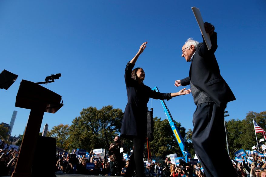 Democratic presidential candidate Sen. Bernie Sanders, I-Vt., hugs Rep. Alexandria Ocasio-Cortez, D-N.Y. during a campaign rally on Saturday, Oct. 19, 2019 in New York. (AP Photo/Eduardo Munoz Alvarez)