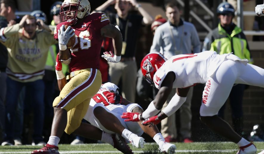 Boston College running back David Bailey (26) scores a touchdown against North Carolina State defensive end Savion Jackson (90) and safety De'Von Graves (14) during the first half of an NCAA college football game in Boston, Saturday, Oct. 19, 2019. (AP Photo/Michael Dwyer)