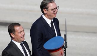 Serbian President Aleksandar Vucic, right, welcomes Russian Prime Minister Dmitry Medvedev prior a military parade at the military airport Batajnica, near Belgrade, Serbia, Saturday, Oct. 19, 2019. Medvedev arrived on a one-day official visit to Serbia during which he attend military parade commemorating the 75th anniversary of the liberation of the Serbian capital from the Nazi German occupation by the Red Army and Communist Yugoslav Partisans. (AP Photo/Darko Vojinovic)