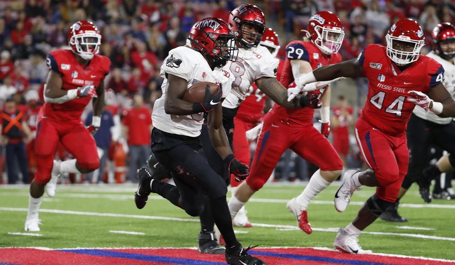 UNLV running back Charles Williams tries to get around Fresno State defensive lineman Leevel Tatum III, right, during the first half of an NCAA college football game in Fresno, Calif., Friday, Oct. 18, 2019. (AP Photo/Gary Kazanjian)