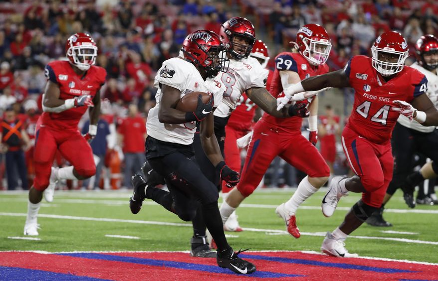UNLV running back Charles Williams tries to get around Fresno State defensive lineman Leevel Tatum III, right, during the first half of an NCAA college football game in Fresno, Calif., Friday, Oct. 18, 2019. (AP Photo/Gary Kazanjian)