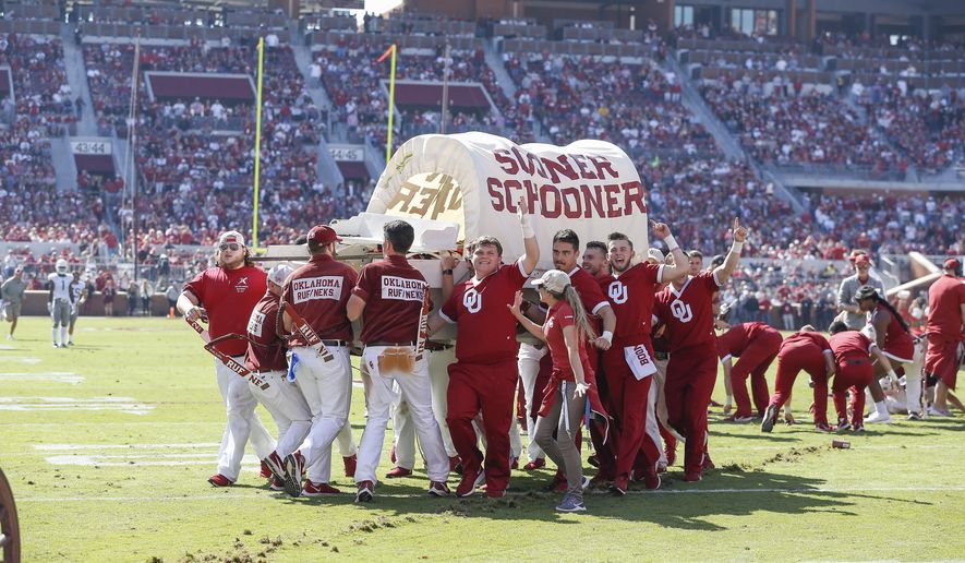 The Oklahoma Sooner Schooner is carried off the field after it tipped over during a celebratory run following a Sooner touchdown during the first half of an NCAA college football game against West Virginia in Norman, Okla., Saturday, Oct. 19, 2019. (AP Photo/Alonzo Adams)