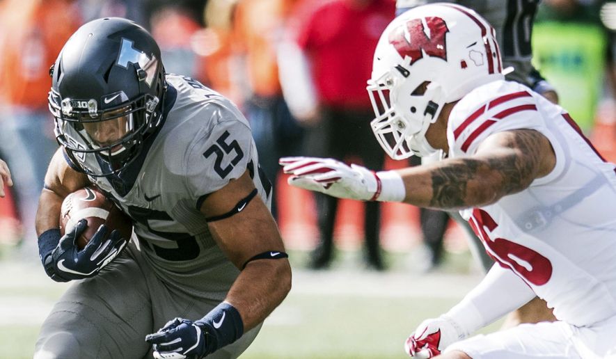 Illinois' Dre Brown runs the ball as Wisconsin's Zack Baun (56) defends in the first half of an NCAA college football game, Saturday, Oct.19, 2019, in Champaign, Ill. (AP Photo/Holly Hart)