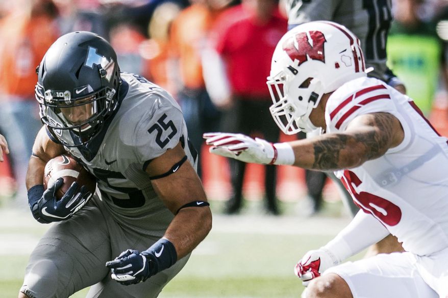 Illinois' Dre Brown runs the ball as Wisconsin's Zack Baun (56) defends in the first half of an NCAA college football game, Saturday, Oct.19, 2019, in Champaign, Ill. (AP Photo/Holly Hart)