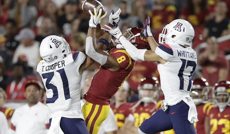 Arizona safety Tristan Cooper (31) and cornerback Jace Whittaker (17) break up a pass intended for Southern California wide receiver Amon-Ra St. Brown (8) during the first half of an NCAA college football game Saturday, Oct. 19, 2019, in Los Angeles. (AP Photo/Marcio Jose Sanchez)