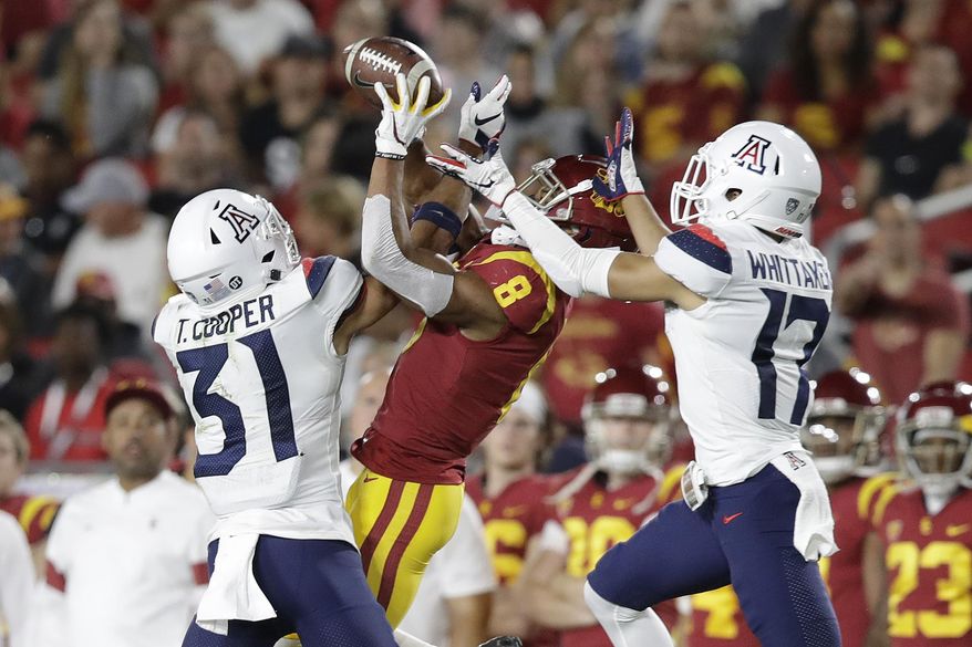 Arizona safety Tristan Cooper (31) and cornerback Jace Whittaker (17) break up a pass intended for Southern California wide receiver Amon-Ra St. Brown (8) during the first half of an NCAA college football game Saturday, Oct. 19, 2019, in Los Angeles. (AP Photo/Marcio Jose Sanchez)