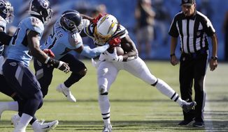 Los Angeles Chargers running back Melvin Gordon, center, is pushed out of bounds by Tennessee Titans cornerback Malcolm Butler (21) in the first half of an NFL football game Sunday, Oct. 20, 2019, in Nashville, Tenn. (AP Photo/James Kenney)