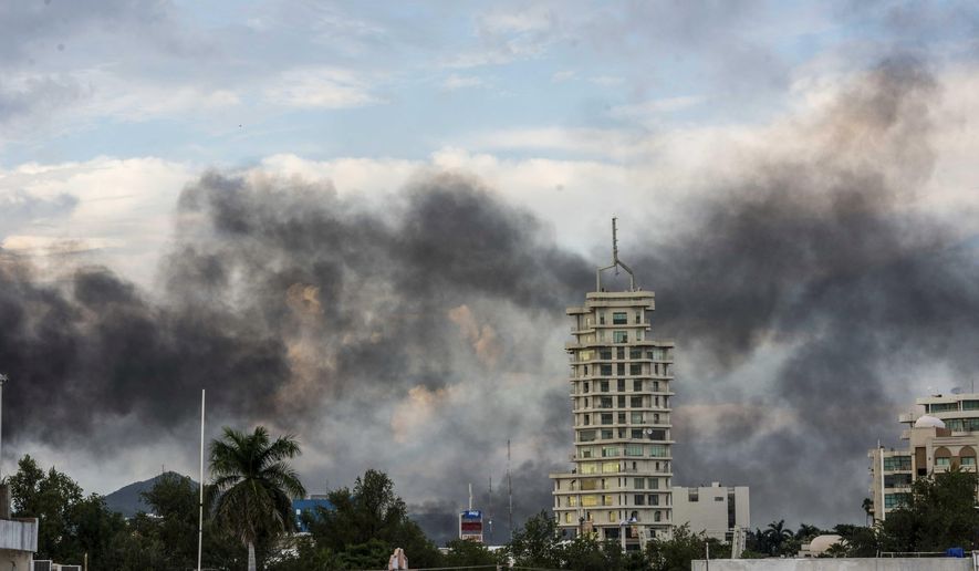 This Oct. 17, 2019 photo shows clouds of smoke from burning cars mar the skyline of Culiacan, Mexico. The Mexican city lived under drug cartel terror for 12 hours as gang members forced the government to free a drug lord. (AP Photo/Hector Parra)