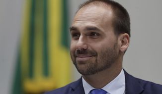 FILE - In this Aug. 14, 2019 file photo, Eduardo Bolsonaro, a Brazilian lawmaker and the son of President Jair Bolosonaro, smiles during a Foreign Relations Committee ceremony, in Brasilia, Brazil. Eduardo Bolsonaro has assumed leadership of their political party, the Social Liberal Party, in Congress’ lower house, an update of the chamber’s website showed Monday, Oct. 21, 2019.  (AP Photo/Eraldo Peres, File)