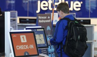 In this Oct. 17, 2019, photo a customer checks in at a kiosk at the JetBlue check in counter at the Richmond International Airport in Sandston, Va. JetBlue Airways Corp. reports financial earns on Tuesday, Oct. 22. (AP Photo/Steve Helber)