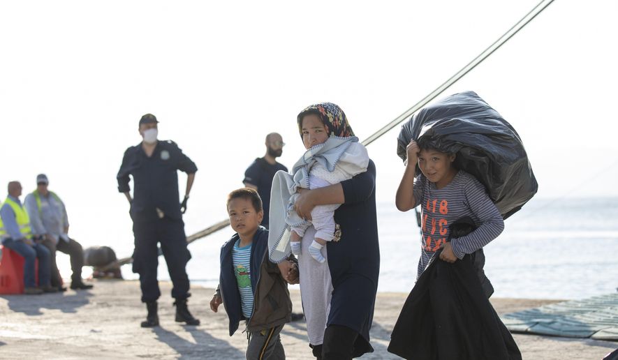 Refugees and migrants disembark from a ferry at the port of Elefsina, near Athens, on Tuesday, Oct. 22, 2019. About 700 refugees and migrants arrived from Samos island to the port of Elefsina as authorities have been moving hundreds of migrants deemed to be vulnerable from the overcrowded Samos camp to camps on the mainland. (AP Photo/Petros Giannakouris)