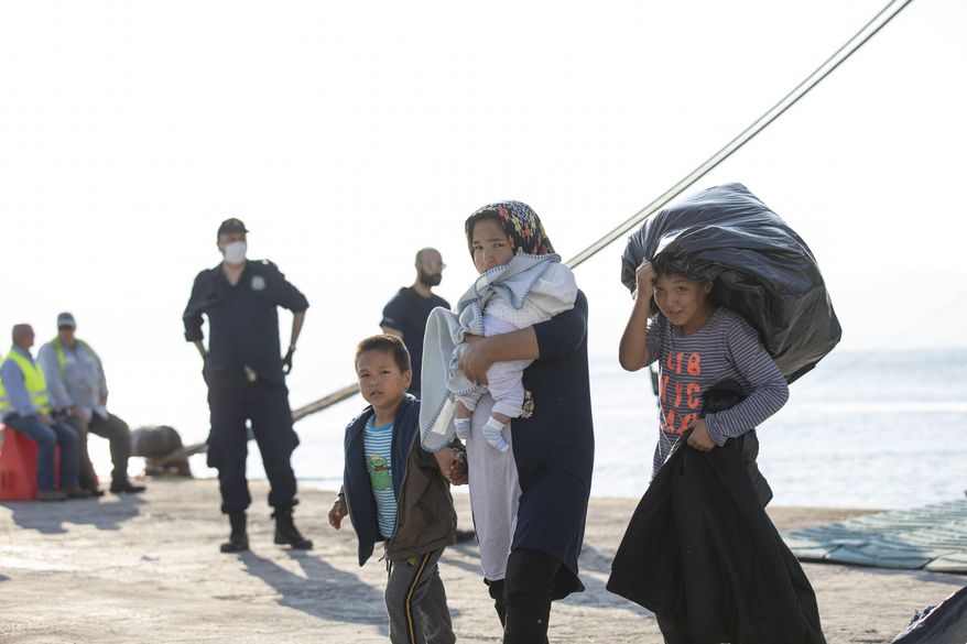 Refugees and migrants disembark from a ferry at the port of Elefsina, near Athens, on Tuesday, Oct. 22, 2019. About 700 refugees and migrants arrived from Samos island to the port of Elefsina as authorities have been moving hundreds of migrants deemed to be vulnerable from the overcrowded Samos camp to camps on the mainland. (AP Photo/Petros Giannakouris)