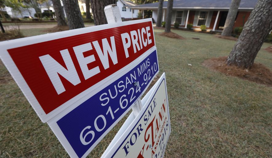 This Sept. 25, 2019, photo shows a sign indicating a new selling price for a house sits atop a realtor's sign in Jackson, Miss. On Tuesday, Oct. 22, the National Association of Realtors reports on sales of existing homes in September. (AP Photo/Rogelio V. Solis)