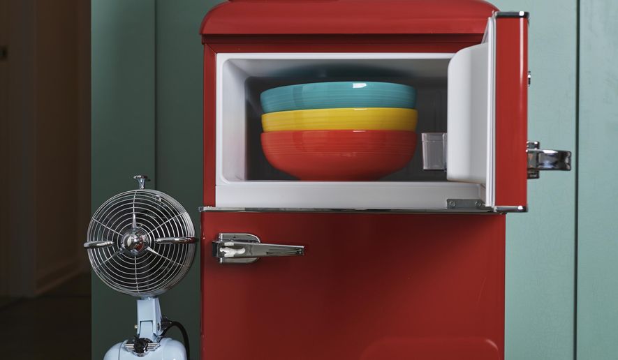 This September 2019 photo provided by Katie Workman shows a variety of kitchen items in different colors, including a red fridge, a yellow stand mixer and some brightly colored bowls and vases, in a New York kitchen. There are a lot of ways to add color to your kitchen. (Cheyenne M. Cohen/Katie Workman via AP)