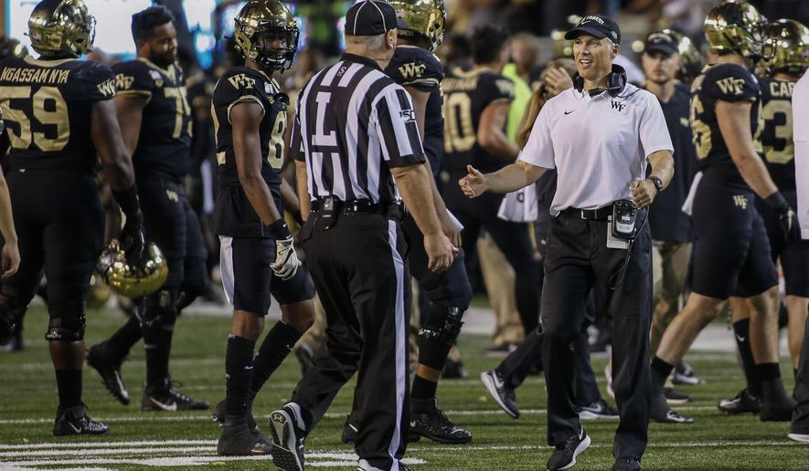 Wake Forest coach Dave Clawson argues with official Kirk Lewis after losing an onside-kick attempt during the second half of the team's NCAA college football game against Louisville in Winston-Salem, N.C., Saturday, Oct. 12, 2019. Louisville won 62-59. (AP Photo/Nell Redmond)