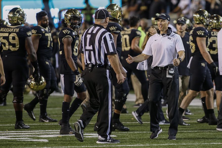 Wake Forest coach Dave Clawson argues with official Kirk Lewis after losing an onside-kick attempt during the second half of the team's NCAA college football game against Louisville in Winston-Salem, N.C., Saturday, Oct. 12, 2019. Louisville won 62-59. (AP Photo/Nell Redmond)