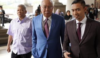 Former Malaysian Prime Minister Najib Razak, center, arrives at Kuala Lumpur High Court in Kuala Lumpur, on Tuesday, Oct. 22, 2019. Najib is facing 42 charges of corruption, abuse of power and money laundering in five separate criminal cases linked to the multibillion-dollar looting of 1MDB. (AP Photo/Vincent Thian)