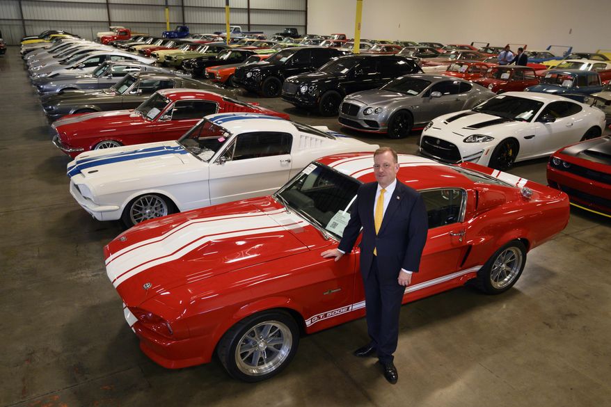 FILE - In this Sept. 16, 2019 photo, McGregor Scott, U.S. Attorney for the Eastern District of California, stands next to a 1967 Ford Shelby GT 500, that was seized along with other cars by the federal government that are now housed in a warehouse in Woodland, Calif. Two employees of a defunct San Francisco Bay Area solar energy company pleaded guilty Tuesday, Oct. 22, 2019, to participating in what federal prosecutors say was a massive $2.5 billion fraud scheme that defrauded investors of $1 billion. It’s the largest single-owner car collection ever auctioned by the U.S. Marshals Service, with vehicles to be auctioned off on Wednesday. (Randy Pench/The Sacramento Bee via AP)