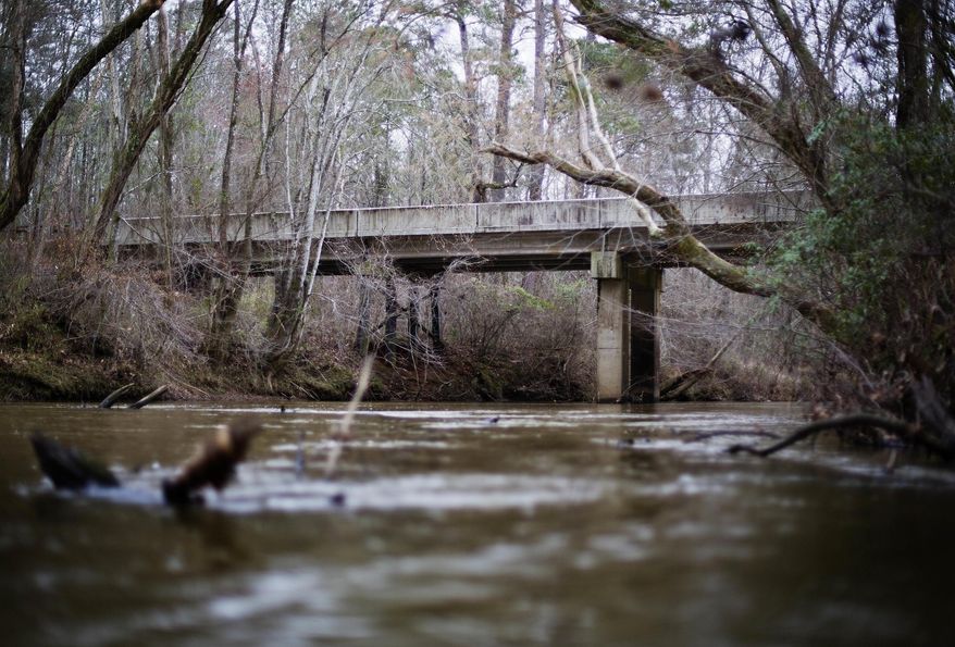 This Feb. 22, 2018, file photo shows a bridge that spans the Apalachee River at Moore's Ford Road where in 1946 two young black couples were stopped by a white mob who dragged them to the riverbank and shot them multiple times in Monroe, Ga. The gruesome lynching is prompting a U.S. court to consider whether federal judges can order grand jury records unsealed in old cases with historical significance. (AP Photo/David Goldman, File) **FILE**