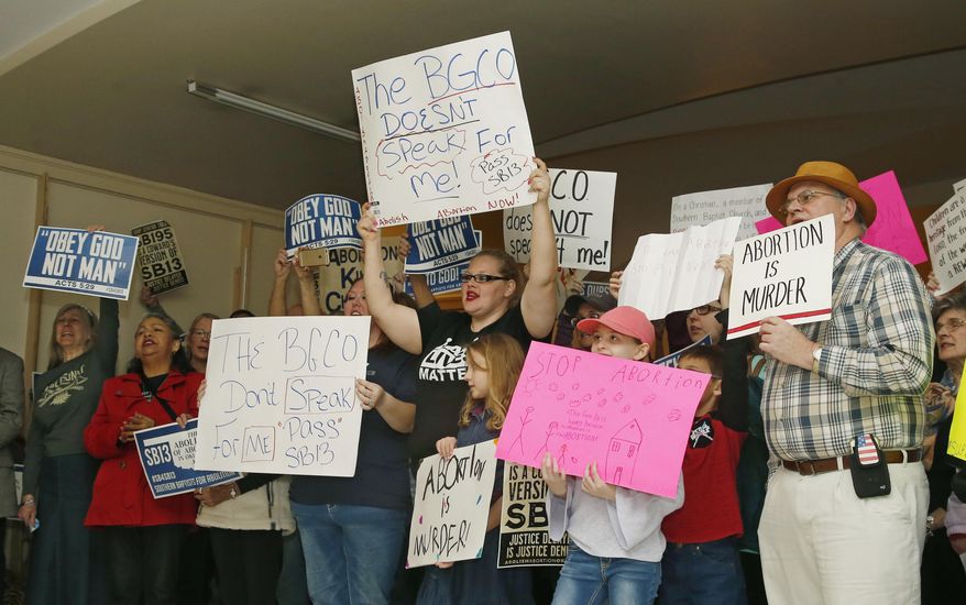 FILE - In this Feb. 25, 2019 file photo, abortion opponents cheer for a speaker at a rally at the state Capitol in Oklahoma City. An Oklahoma judge will hear arguments Wednesday, Oct. 23 on a challenge to a new law in Oklahoma that would allow doctors who perform medication abortions to face felony charges for not informing women about the possibility of reversing the process. Several medical groups argue the requirement would force doctors to provide patients with scientifically dubious information. (AP Photo/Sue Ogrocki, File)
