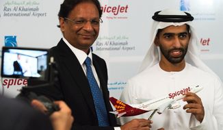 SpiceJet chairman and managing director Ajay Singh, left, and Sheikh Khalid bin Saud Al Qasimi, a son of Ras al-Khaimah ruler Sheikh Saud bin Saqr Al Qasimi, right, pose for photographs during a news conference in Ras al-Khaimah, United Arab Emirates, Wednesday, Oct. 23, 2019. India&#39;s low-cost airline SpiceJet announced plans Wednesday to build its first international hub in the United Arab Emirates, offering a pledge of support to Boeing Co. by saying it would use now-grounded 737 MAX aircraft in the operation once regulators approve the planes for flight. (AP Photo/Jon Gambrell)