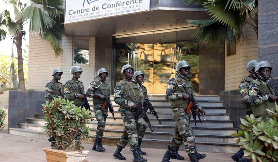 In this Saturday, Nov. 21, 2015, file photo, soldiers from the presidential guard patrol outside the Radisson Blu hotel in Bamako after it was attacked by Islamic extremists armed with guns and grenades. Islamic extremists have displaced half a million people this year in the border area between Burkina Faso and Mali as their threat continues to spread in West Africa&#39;s Sahel region. The fighters linked to al Qaeda and the Islamic State group are exploiting military and government weaknesses as well as local grievances. A regional counterterror force has failed to stop the attacks and has become a target itself. (AP Photo/Jerome Delay, File)