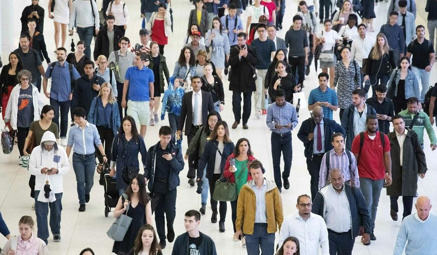 FILE - In this June 21, 2019, file photo, commuters walk through a corridor in the World Trade Center Transportation Hub, in New York. The United States will add 79 million people in the next 40 years, but growth will slow as the U.S population gets older, according to new projections presented Thursday at a meeting of demographers. (AP Photo/Mark Lennihan, File)