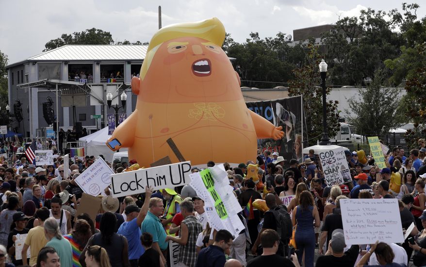 In this June 18, 2019, file photo, an inflatable Baby Trump balloon towers over protesters during a rally in Orlando, Fla. A coalition of liberal groups is hoping to take the fight over House Democrats’ impeachment inquiry of President Donald Trump to the streets. (AP Photo/Chris O'Meara, File)