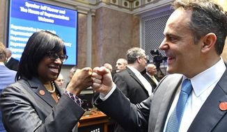 FILE - In this Jan. 3, 2017 file photo, Kentucky Gov. Matt Bevin, right, and Kentucky Lt. Governor Jenean Hampton bump fists as they await the swearing in of Jeff Hoover as Speaker of the Kentucky House of Representatives in Frankfort, Ky. Kentucky Gov. Matt Bevin has won another round of a legal fight with his lieutenant governor over who wields hiring and firing authority over the lieutenant governor’s staff. A judge ruled Friday, Oct. 25, 2019 that the Republican governor has “superseding authority” to hire and fire employees assigned to the lieutenant governor’s office. (AP Photo/Timothy D. Easley, File)