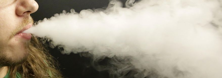 In this Aug. 14, 2014, file photo, a man exhales vapor as he demonstrates the use of his electronic cigarette in Salt Lake City. (AP Photo/Rick Bowmer, File) **FILE**
