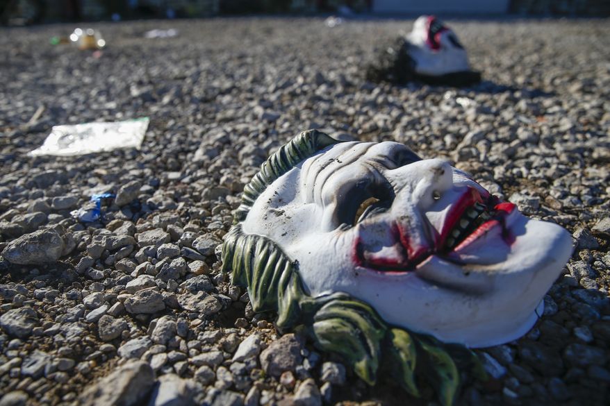 Halloween masks litter the ground amongst signs of chaos at the scene where a mass shooting occurred the night before at Party Venue on Highway 380 in Greenville, Texas, on Sunday, October 27, 2019. As of early Sunday morning a gunman is still at large after killing at least two people and injuring 14 at Party Venue Saturday night, according to Chief Deputy Buddy Oxford of the Hunt County Sheriff's Department. (Ryan Michalesko/The Dallas Morning News via AP)