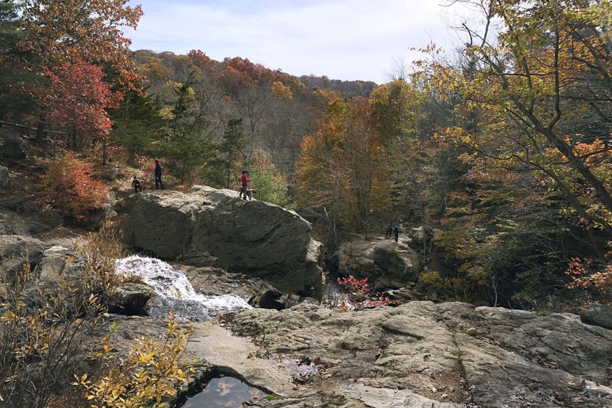 In this Friday, Oct. 25, 2019, photo, people enjoy an autumn day at Devil's Hopyard State Park, in East Haddam, Conn. The Connecticut Department of Energy and Environmental Protection has been awarded more than $150,000 in federal funds for the acquisition of nearly 100 acres to be added to the park. (AP Photo/Susan Haigh)