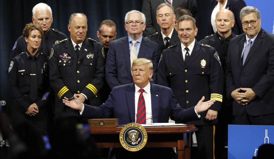 President Donald Trump solicits response from the crowd before signing an executive order creating a commission to study law enforcement and justice at the International Association of Chiefs of Police Convention Monday, Oct. 28, 2019, in Chicago. (AP Photo/Charles Rex Arbogast)