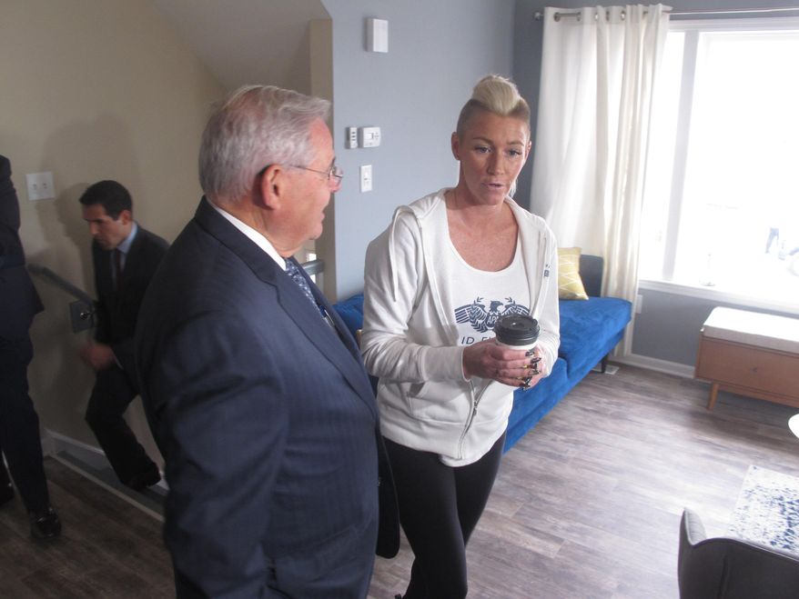 U.S. Sen Robert Menendez of New Jersey, left, tours the newly rebuilt Toms River, N.J. home of Heather Shapter, right, on Oct. 28, 2019, a day before the seventh anniversary of Superstorm Sandy. New Jersey officials say about 700 people enrolled in its main post-Sandy rebuilding program still have not finished their homes. (AP Photo/Wayne Parry)