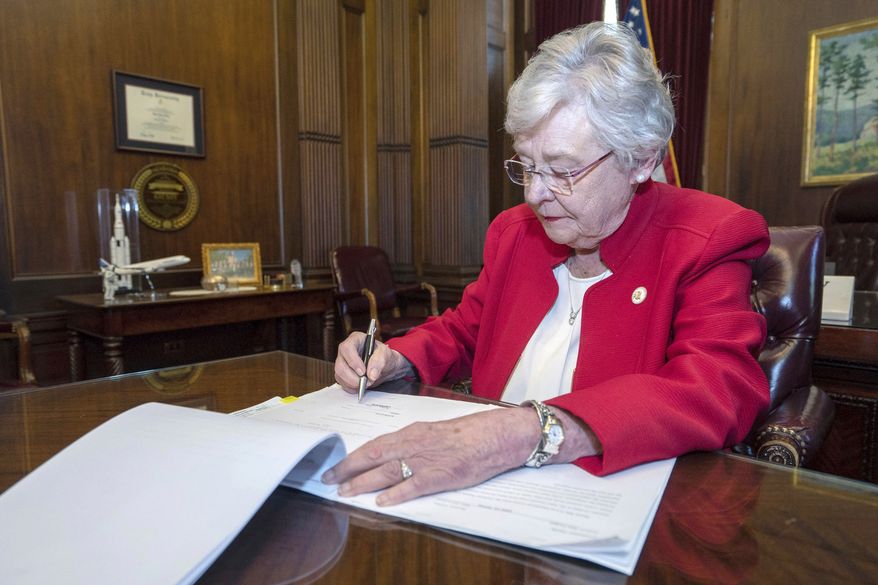 This Wednesday, May 15, 2019, photo released by the state shows Alabama Gov. Kay Ivey signing a bill that virtually outlaws abortion in the state, in Montgomery, Ala. U.S. District Judge Myron Thompson on Tuesday, Oct. 29, 2019, has blocked an Alabama abortion ban that would have made the procedure a felony at any stage of pregnancy in almost all cases. (Hal Yeager/Alabama Governor's Office via AP) **FILE**