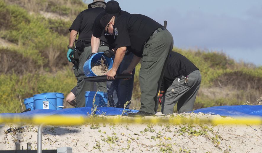 Several state agencies conduct an investigation on a Padre Island, Texas beach in Kleberg County after human remains were found on Monday, Oct. 28, 2019. The Kleberg County Sheriff's Office says a deputy located a woman's remains Sunday in a shallow grave on Padre Island, near Corpus Christi. Chief Deputy Jaime Garza says a man's body was discovered Monday beneath the first body. (Courtney Sacco/Corpus Christi Caller-Times via AP)