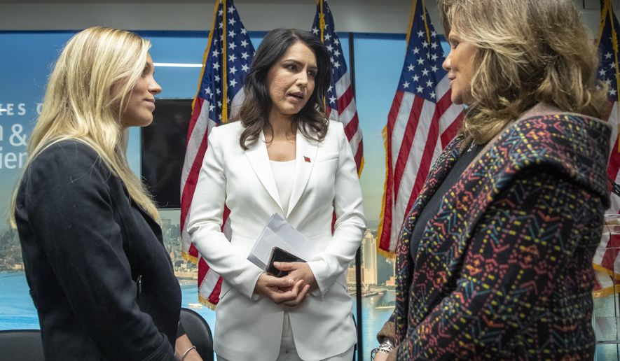 Democratic presidential candidate U.S. Rep. Tulsi Gabbard, center, D-Hawaii, talks to Kaitlyn, left and her mother Terry Strada whose father Tom died during the terrorist attack on 9/11 during a news conference at the 9/11 Tribute Museum, Tuesday, Oct. 29, 2019, in New York. (AP Photo/Mary Altaffer)