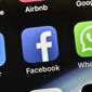 In this Nov. 15, 2018, file photo the icons of Facebook and WhatsApp are pictured on an iPhone in Gelsenkirchen, Germany. (AP Photo/Martin Meissner, File)