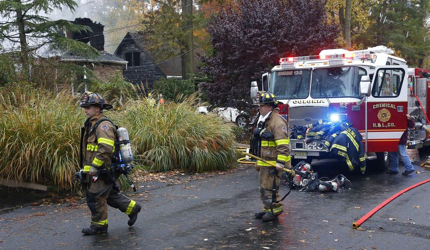 Woodbridge firefighters work the scene of fire after a plane crashed into a home located at 84 Berkeley Ave. Tuesday, Oct. 29, 2019, in Woodbridge,N.J. (AP Photo/Noah K. Murray)
